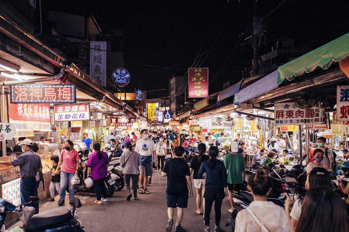 屏東觀光夜市民族路傍晚街景,招牌亮起、人潮沿街移動